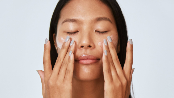 person applying moisturizer on face